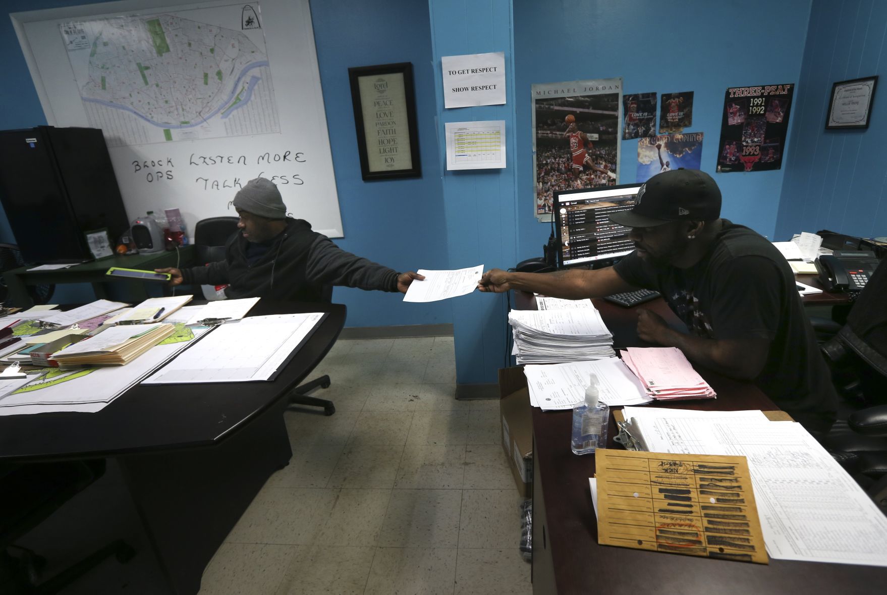 Supervisor Will Young hands a CSB complaint to foreman Tony Stokes